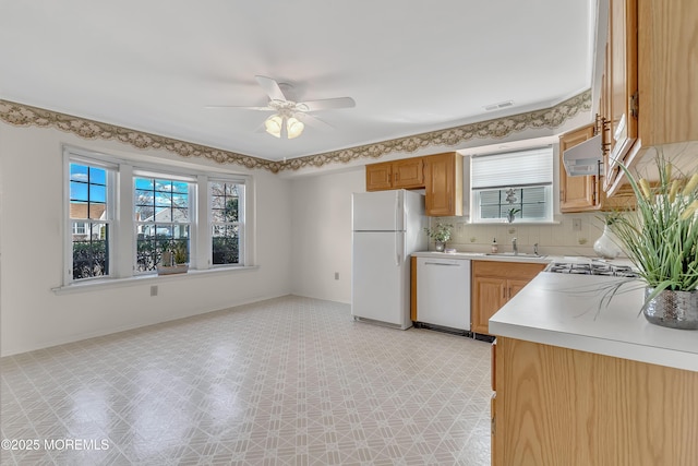 kitchen with light floors, light countertops, visible vents, white appliances, and baseboards