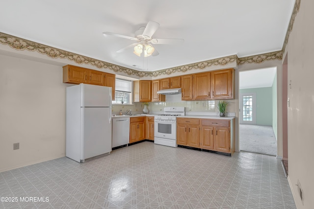 kitchen featuring white appliances, under cabinet range hood, light countertops, and a ceiling fan