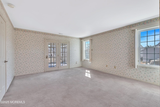 carpeted spare room with baseboards and wallpapered walls