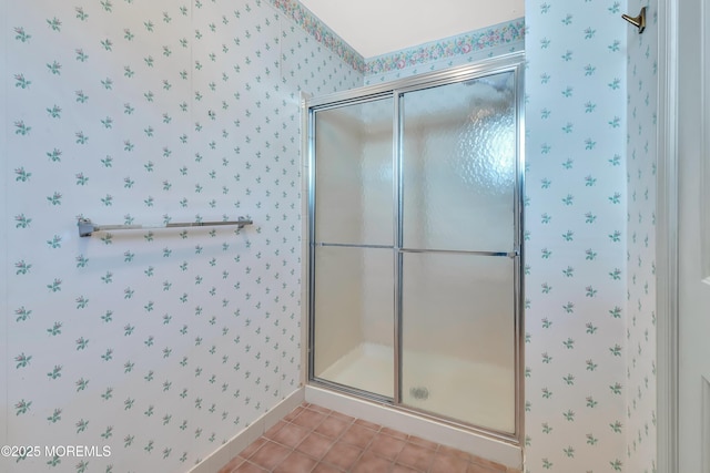 bathroom with a shower stall, baseboards, tile patterned flooring, and wallpapered walls