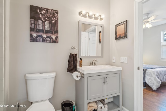 full bathroom featuring a ceiling fan, connected bathroom, toilet, wood finished floors, and vanity