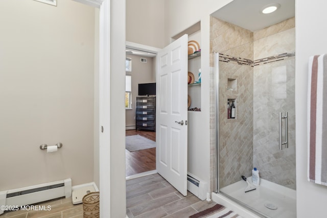 bathroom featuring a baseboard heating unit, wood tiled floor, a shower stall, and a baseboard radiator