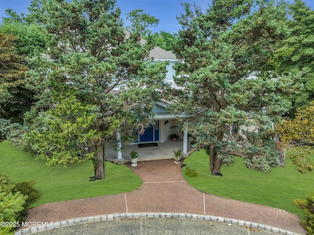 view of front of house with roof with shingles and a front lawn