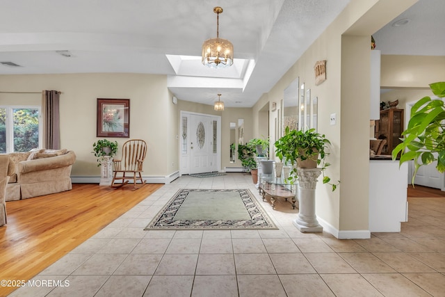 entryway featuring light tile patterned floors, a skylight, baseboards, visible vents, and baseboard heating