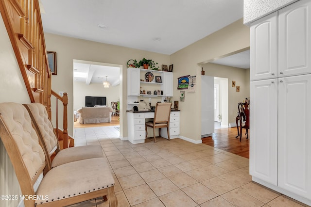 home office featuring light tile patterned floors, baseboards, and built in desk