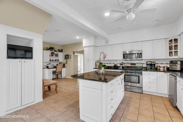 kitchen with stainless steel appliances, white cabinetry, glass insert cabinets, and a kitchen island