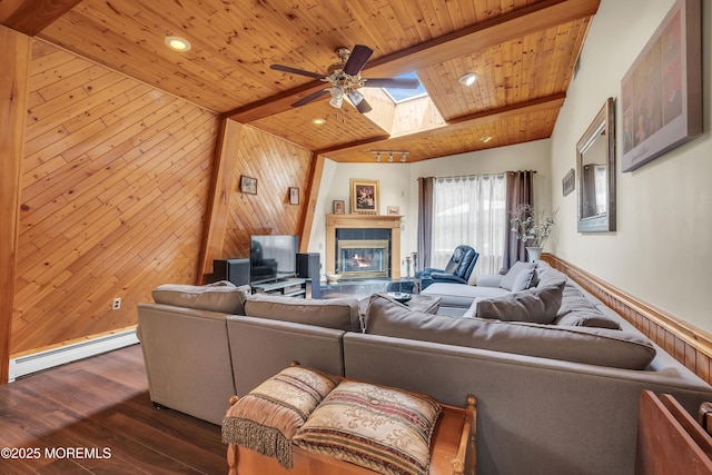 living room with wooden ceiling, a baseboard heating unit, wood walls, dark wood finished floors, and a glass covered fireplace