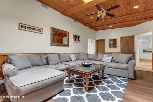 living area featuring visible vents, a ceiling fan, wooden ceiling, wood finished floors, and beam ceiling