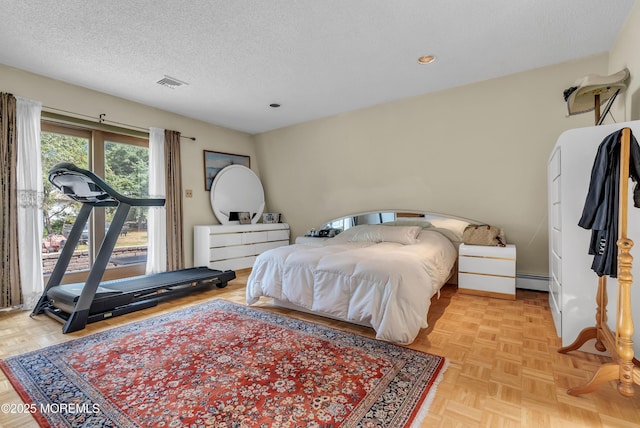 bedroom with a baseboard radiator, visible vents, and a textured ceiling