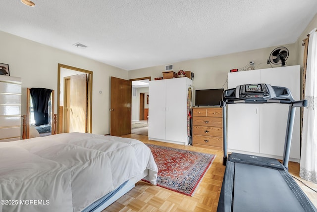 bedroom with a textured ceiling and visible vents