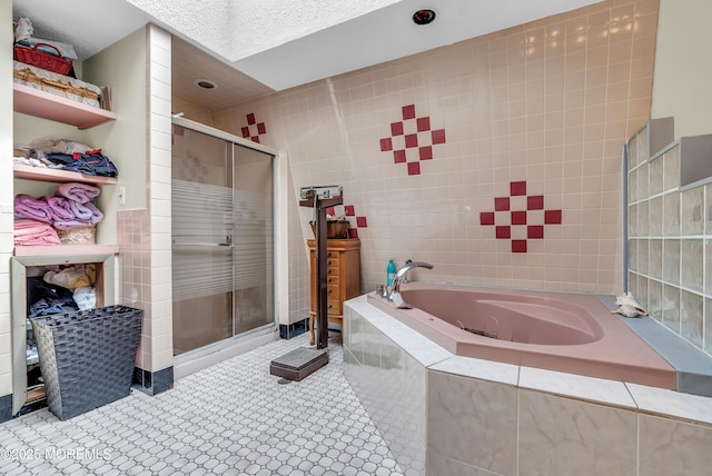 bathroom featuring a stall shower, a garden tub, and tile walls