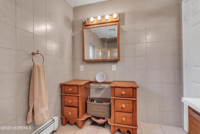 bathroom featuring tile walls, tile patterned floors, baseboard heating, vanity, and walk in shower