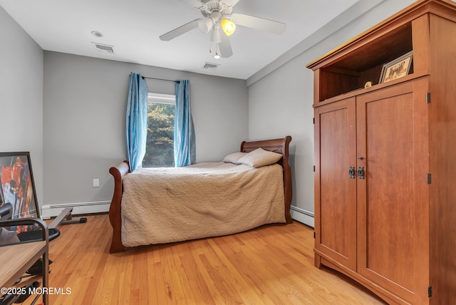 bedroom with light wood finished floors, baseboard heating, and visible vents