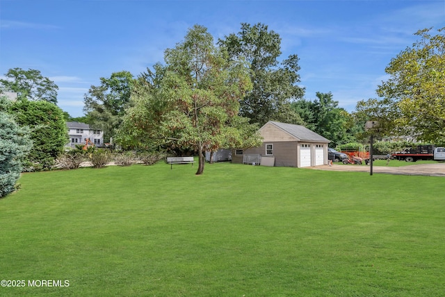 view of yard featuring a garage and an outdoor structure