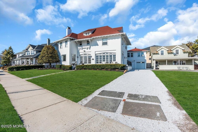 view of front of home with a garage, a residential view, and a front yard