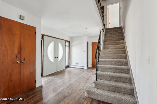 foyer featuring dark wood-style floors, a baseboard radiator, and stairs