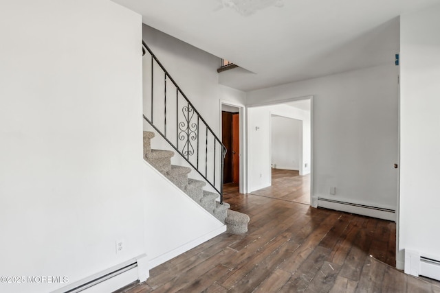 interior space featuring a baseboard radiator, dark wood-style flooring, and stairway