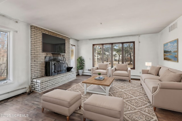 living room with a wealth of natural light, visible vents, and wood finished floors