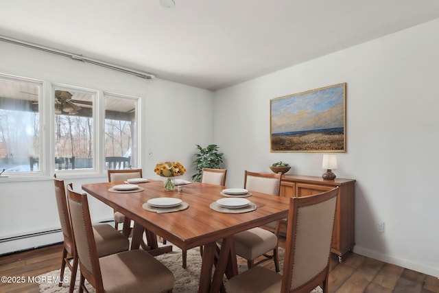 dining space featuring dark wood finished floors, a ceiling fan, and baseboards