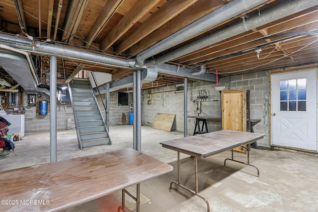 unfinished below grade area with stairs and washer / clothes dryer