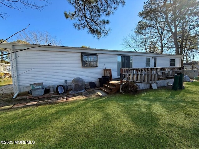 rear view of house with a deck and a yard