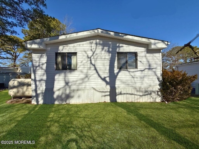 view of property exterior with a yard and heating fuel