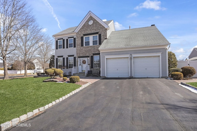 view of front facade with an attached garage, brick siding, driveway, roof with shingles, and a front lawn