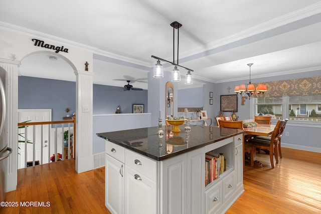 kitchen with visible vents, white cabinets, hanging light fixtures, a center island, and dark stone counters