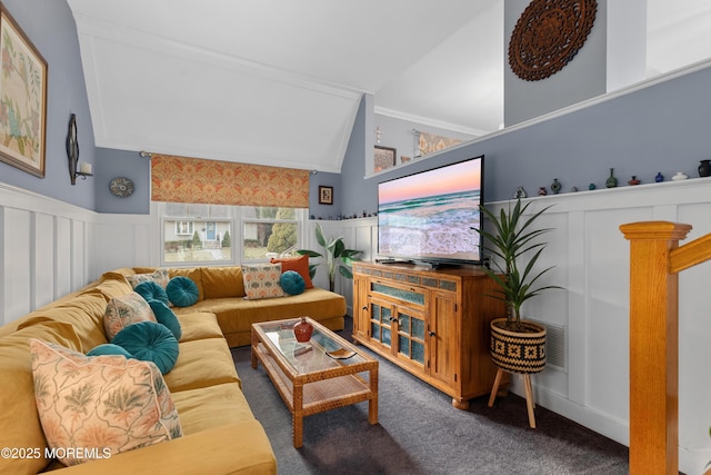 carpeted living area featuring lofted ceiling and a wainscoted wall