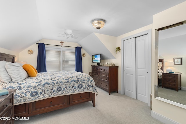 bedroom featuring baseboards, vaulted ceiling, a closet, and light colored carpet