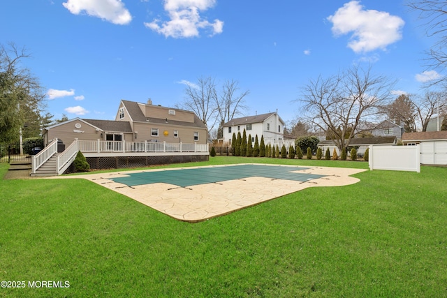 view of pool with a lawn, a wooden deck, a fenced in pool, and fence