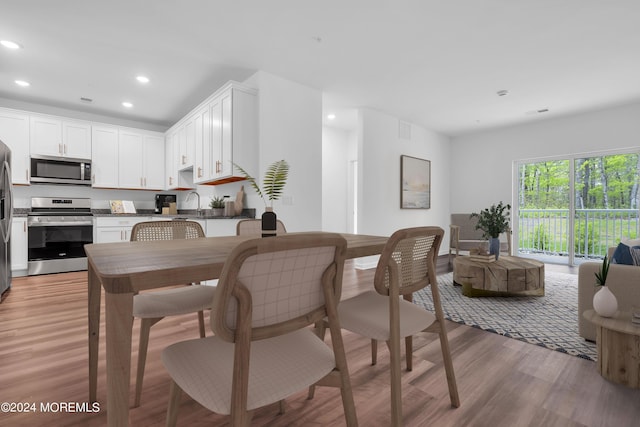 dining area featuring light wood-type flooring and recessed lighting