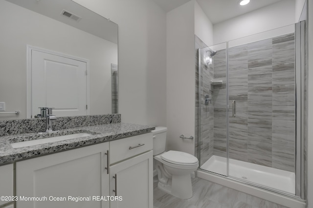 bathroom with toilet, a stall shower, visible vents, and vanity