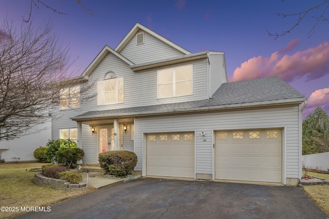 traditional-style home featuring aphalt driveway and roof with shingles