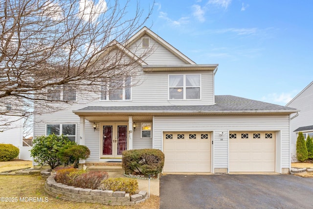 view of front facade featuring a garage, french doors, driveway, and a shingled roof