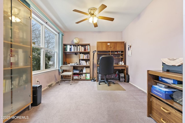 carpeted home office featuring visible vents, ceiling fan, and baseboards