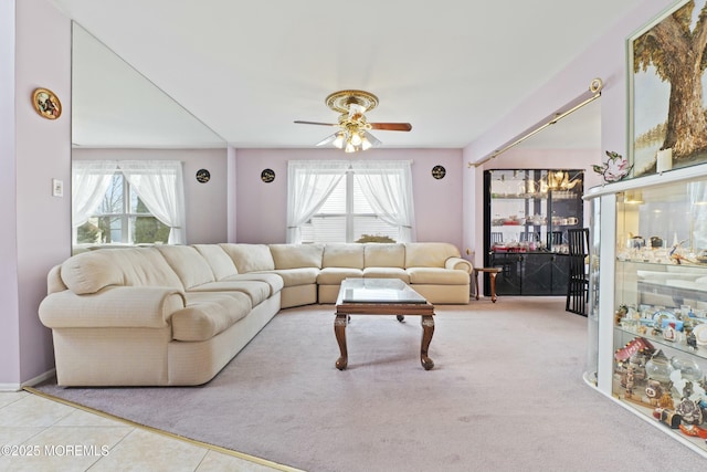 living area featuring carpet, ceiling fan, and tile patterned floors