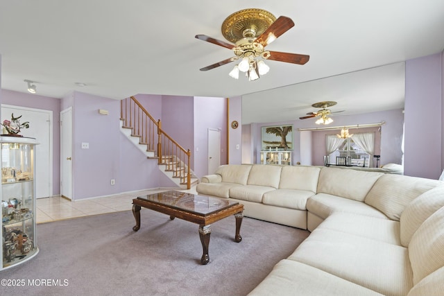 carpeted living room with stairs, tile patterned flooring, and a ceiling fan