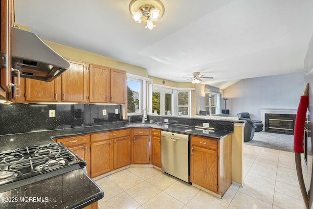 kitchen featuring stainless steel dishwasher, light tile patterned flooring, a sink, ventilation hood, and a peninsula