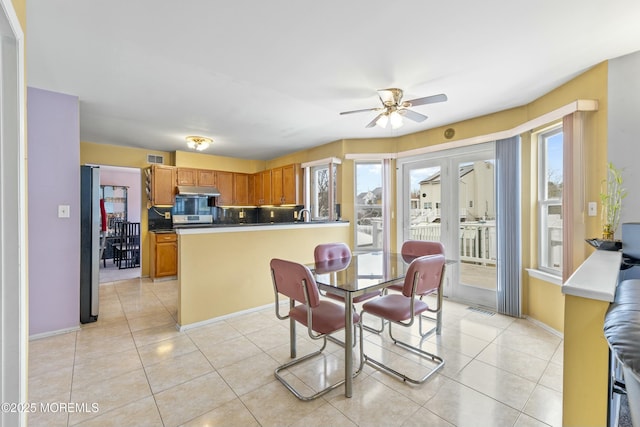 dining space with visible vents, ceiling fan, and light tile patterned floors