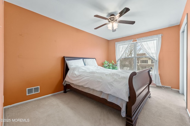 carpeted bedroom featuring baseboards, visible vents, and a ceiling fan