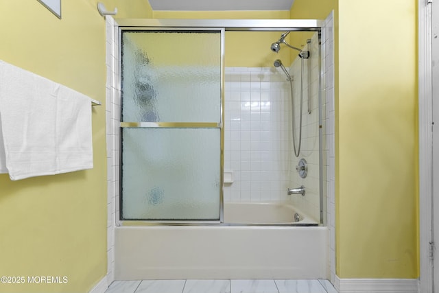 full bathroom featuring shower / bath combination with glass door, baseboards, and marble finish floor