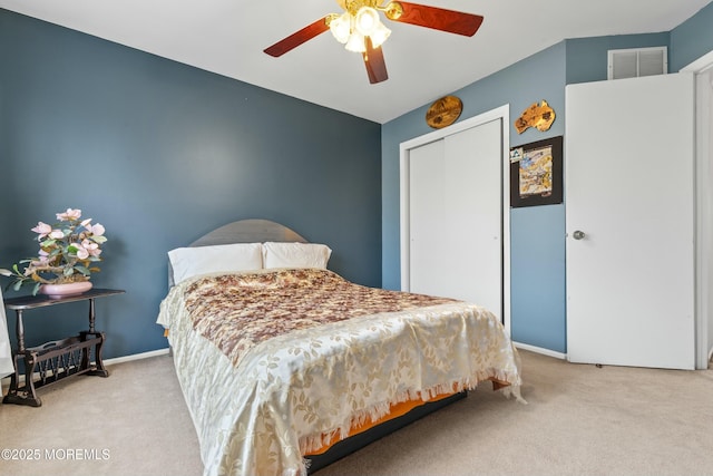 carpeted bedroom with visible vents, a closet, a ceiling fan, and baseboards