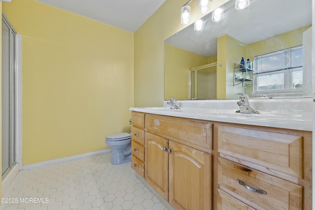 full bathroom featuring toilet, a stall shower, a sink, baseboards, and tile patterned floors