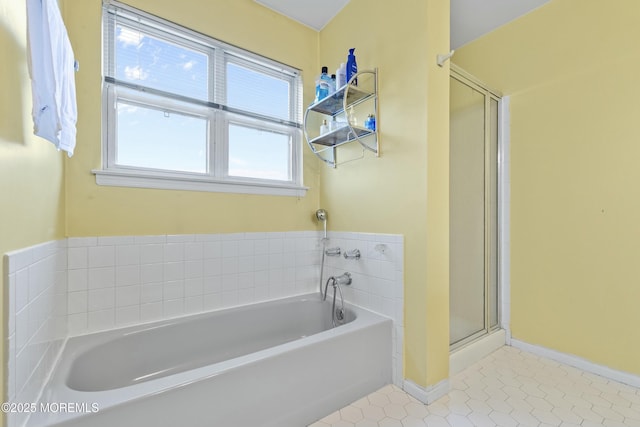 full bathroom featuring a stall shower, tile patterned flooring, a garden tub, and baseboards