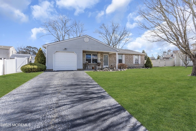 view of front of property with aphalt driveway, brick siding, a front yard, fence, and a garage