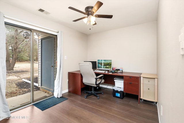 home office with ceiling fan, dark wood-style flooring, visible vents, and baseboards