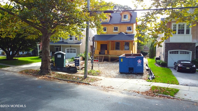 view of front of home with driveway and roof with shingles