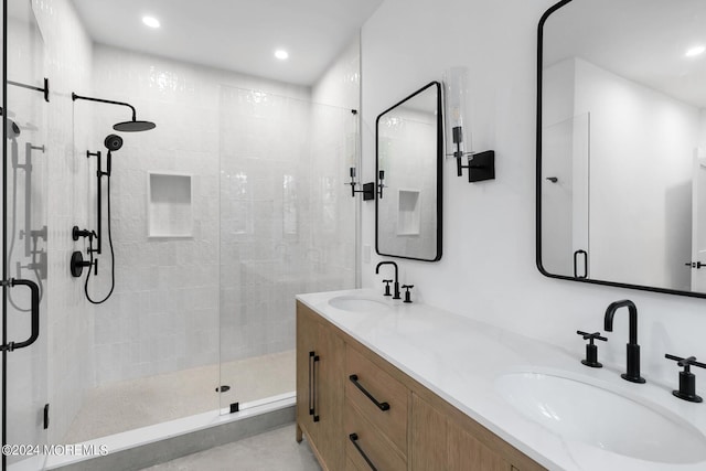 full bathroom featuring a stall shower, a sink, recessed lighting, and double vanity