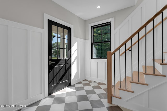 121 Black Point Rd, Rumson, NJ 07760 - foyer entrance with a decorative wall, plenty of natural light, tile patterned floors, a wainscoted wall, and stairs